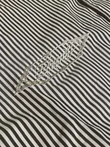 Camisa de manga corta con corte híbrido boxy fit/oversize, confeccionada en algodón. Disponible en tres diseños: a cuadros marrones, a rayas blancas y negras, y a rayas burdeos y blancas. Presenta bordados de diseño propio de la marca.