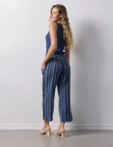 Pantalón capri de algodón estampado a rayas verticales en tonos celeste, rosa y beige. Tiene pretina elastizada, bolsillos delanteros y tajos laterales con botones.