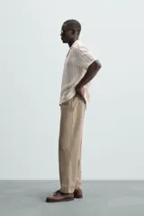 Camisa de hombre a rayas verticales color beige y blanco, de corte relaxed fit, manga corta y cuello bowling.