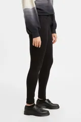 Pantalón de jean negro, tiro medio, corte super skinny.