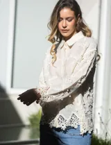 Camisa de algodón color crema, marca Liv Los Angeles, con bordado floral y terminaciones en crochet en puños y ruedo. Tiene cuello con solapa y abertura central con botones.