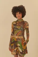 Blusa de tul con cuello polera y mangas largas. Presenta un estampado de hojas en tonos marrones, verdes y amarillos.