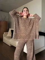 Conjunto de sweater y pantalón de lana y algodón con estampado animal print. El sweater es oversize, con cuello redondo y mangas 3/4. El pantalón es de corte palazzo.