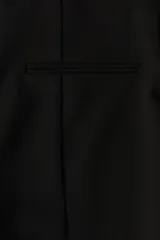 Pantalón de sarga negro con cierre oculto y corchete en un lateral, y bolsillo ribeteado decorativo atrás. Piernas ajustadas de corte recto con abertura en la parte posterior del bajo y pliegues cosidos adelante y atrás.