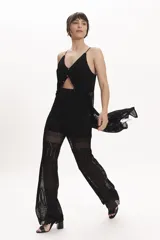 Pantalón palazzo de punto calado negro, con cintura elástica y corte acampanado.