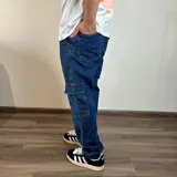 Pantalón de jean azul, corte recto, con bolsillos cargo laterales.