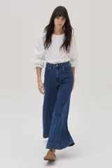 Blusa blanca de mangas largas abullonadas con puños elásticos y lazos.