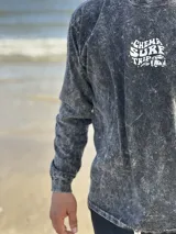 Buzo gris con efecto lavado, cuello redondo y puños acanalados. Estampado en el frente con la frase "Chema Surf Trip" y un dibujo de una camioneta combi.
