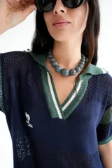 Remerón tejido calado con cuello estilo camisa, color azul marino con detalles en verde y blanco.