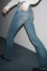 Pantalón de jean azul oscuro, de tiro bajo, corte slim fit y bootcut. Con cinco bolsillos y cierre frontal con cremallera y botón.