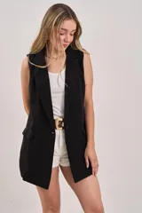 Chaleco sastrero negro sin mangas, con solapas y cierre frontal con un botón. Tiene bolsillos laterales simulados.