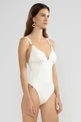 Traje de baño enterizo color marfil con textura de serpiente y escote en V. Presenta breteles finos con apliques florales dorados.