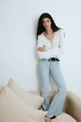 Pantalón de jean celeste de tiro bajo, corte ajustado en la cadera y acampanado desde la rodilla.