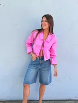 Camisa rosa de lino con cuello, manga larga con puños acampanados y cierre frontal anudado.