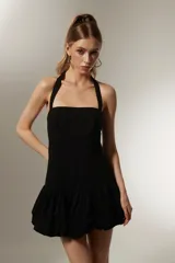 Vestido mini negro sin mangas de algodón, con cuello recto, corte ajustado y falda con volados.
