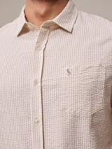 Camisa de manga corta con rayas verticales azules y blancas, confeccionada en algodón.