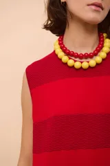 Vestido largo rojo con textura de ondas horizontales y cuello redondo. Sin mangas y de corte recto.