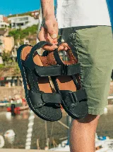 Sandalias negras de cuero con tiras ajustables con velcro.