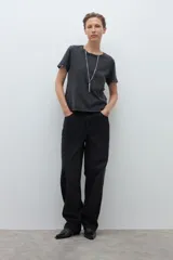 Remera de algodón color gris oscuro con efecto lavado, cuello redondo y mangas cortas decoradas con ojalillos metálicos en el borde.