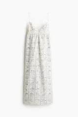 Vestido largo con estampado de motivos marinos en tonos azules, escote en V y tirantes finos que se cruzan en la espalda.
