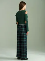 Saco de algodón verde con aberturas en hombros y codos, de corte entallado. Tiene cuello en V, botones pequeños y plaqueta de tejido puño color crudo.