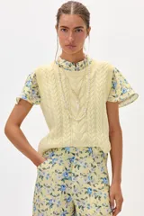 Chaleco amarillo de hilo con diseño trenzado.