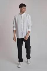 Camisa blanca de lino con cuello abotonado, manga larga con puños abotonados y corte clásico.