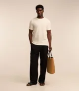 Remera de hombre color crudo, de punto calado con textura de encaje, cuello redondo y mangas cortas. Corte regular. Confeccionada en poliéster y algodón.