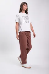 Remera blanca de algodón con estampa frontal de la palabra "Paris" repetida tres veces en letras plateadas con efecto fotográfico.