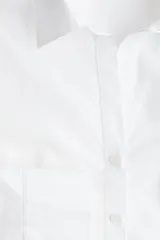 Camisa entallada blanca de manga larga con cuello clásico, tapeta de botones parcialmente abierta y pinzas delanteras y traseras para estilizar la figura.