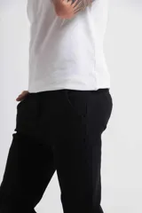 Jeans negros de corte ajustado, con costuras visibles y diseño clásico.