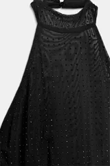 Top negro con cuello halter y espalda descubierta, con aplicación de brillos y cierre de botones en la espalda.