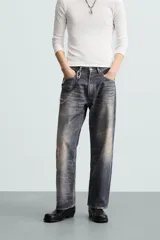 Pantalón de jean azul con lavado gastado, corte holgado y cinco bolsillos.