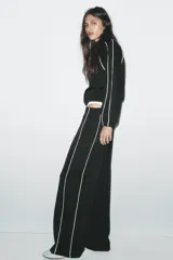 Pantalón negro capri de tiro alto con bolsillos delanteros, cintura elástica y banda lateral blanca a contraste.