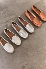 Mocasines de cuero color marrón claro con costuras a la vista.