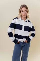 Sweater de manga larga con diseño de rayas anchas horizontales en azul marino y blanco. Posee cuello polo con cartera de botones y calce relajado.