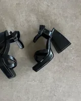 Sandalias negras de plataforma con tiras finas y hebilla al tobillo.