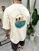 Remera beige de algodón con estampado en la espalda de una ola, palmeras y la frase "May the waves be good where you are".