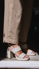 Sandalias de plataforma color borgoña, confeccionadas en charol. Tienen dos tiras anchas sobre el empeine, pulsera con hebilla al tobillo y taco cuadrado de 9 cm.