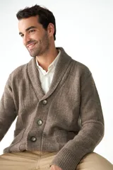 Cardigan tejido color marrón con cuello smoking, cierre con botones y bolsillos delanteros.