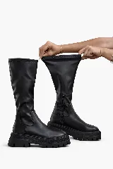 Botas bucaneras negras de caña alta, con caña elástica y cierre lateral. Cuentan con suela track gruesa y plataforma.