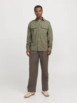 Sobrecamisa de manga larga color verde oliva con rayas verticales finas en tono más claro. Tiene cuello clásico, cierre con botones, dos bolsillos en el pecho con cierre de botón y puños abotonados. Corte recto y cómodo. Confeccionada en tejido de sarga de algodón y lino.