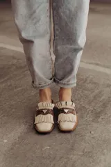 Zueco de cuero color crudo con detalle de flecos y pieza central en cuero snake.