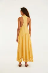 Vestido largo amarillo sin mangas, con bordados calados en el ruedo y diseño de palmeras.