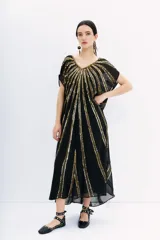 Vestido largo tipo kaftan color negro, con escote en V y mangas cortas. Confeccionado en georgette con bordados de lentejuelas doradas. Incluye viso con escote en V, puntilla y breteles regulables.