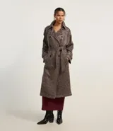 Trench coat largo color marrón con efecto teñido, cuello inglés, manga larga, cierre doble con botones delanteros y cinto para lazo en la cintura.