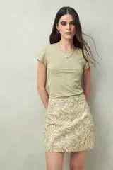 Minifalda de algodón color beige con estampado de hojas en verde claro.