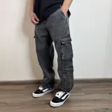 Pantalón jean cargo gris oscuro con corte baggy y bolsillos laterales con fuelle.