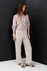 Pantalón de lino color blanco, tiro alto, corte recto y holgado, con pinzas delanteras y pespuntes a contratono.