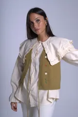 Chaleco tejido color crema con escote en V y cierre frontal con lazos. Presenta bordados de flores en tonos naranja, verde y blanco.